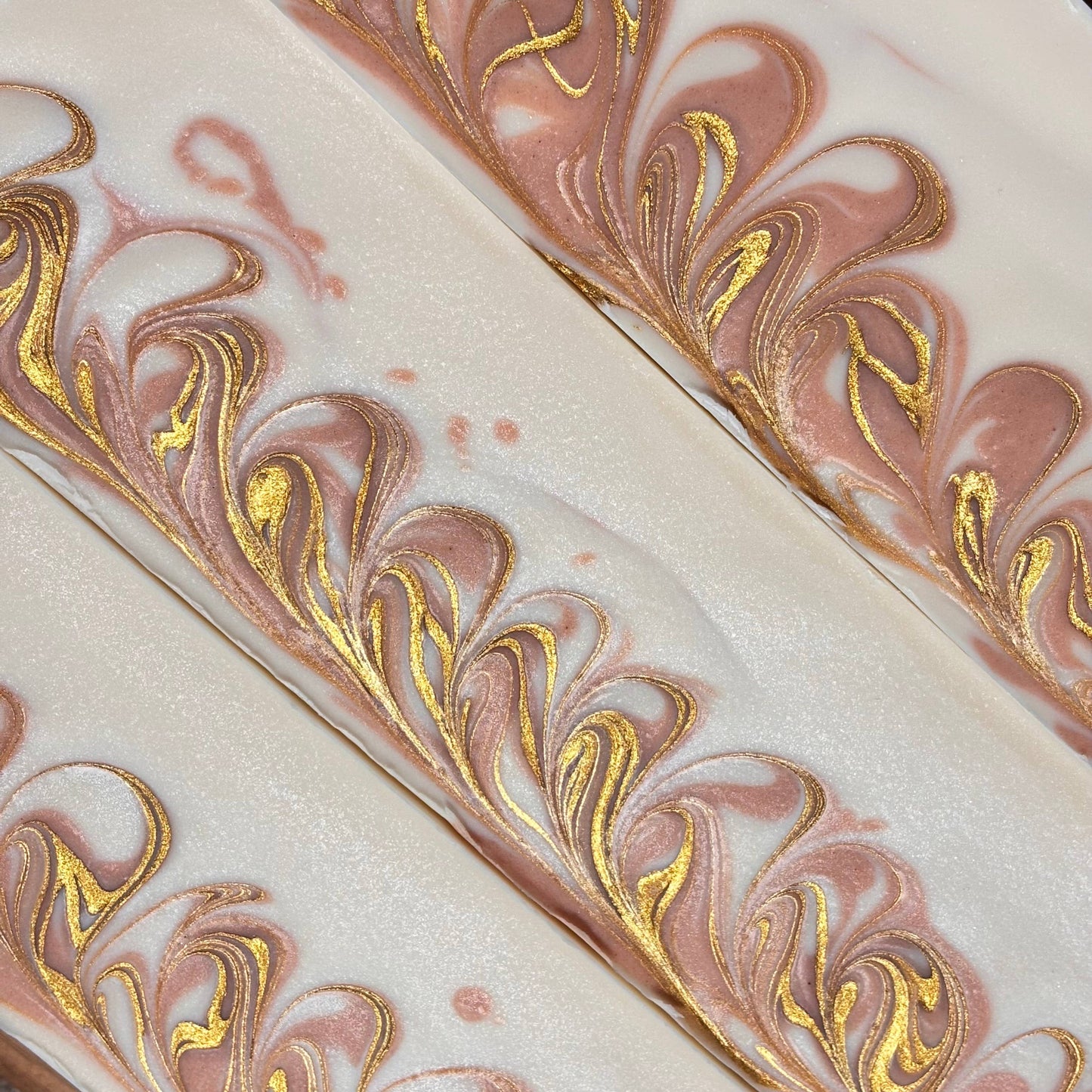 Marbled surface with gold leaf patterns on a pink and white background