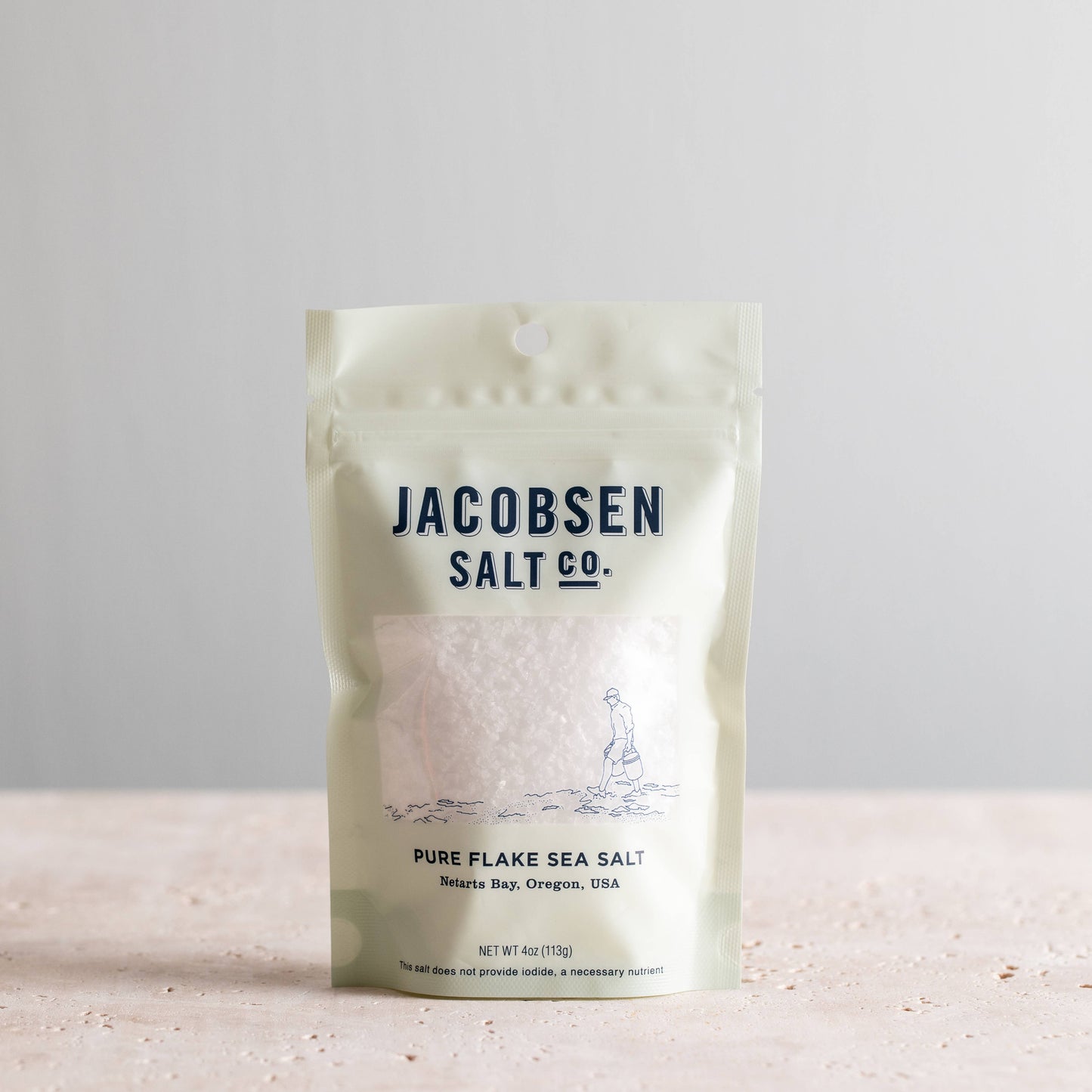 Packaging of Jacobsen Salt Co. pure flake sea salt on a light background
