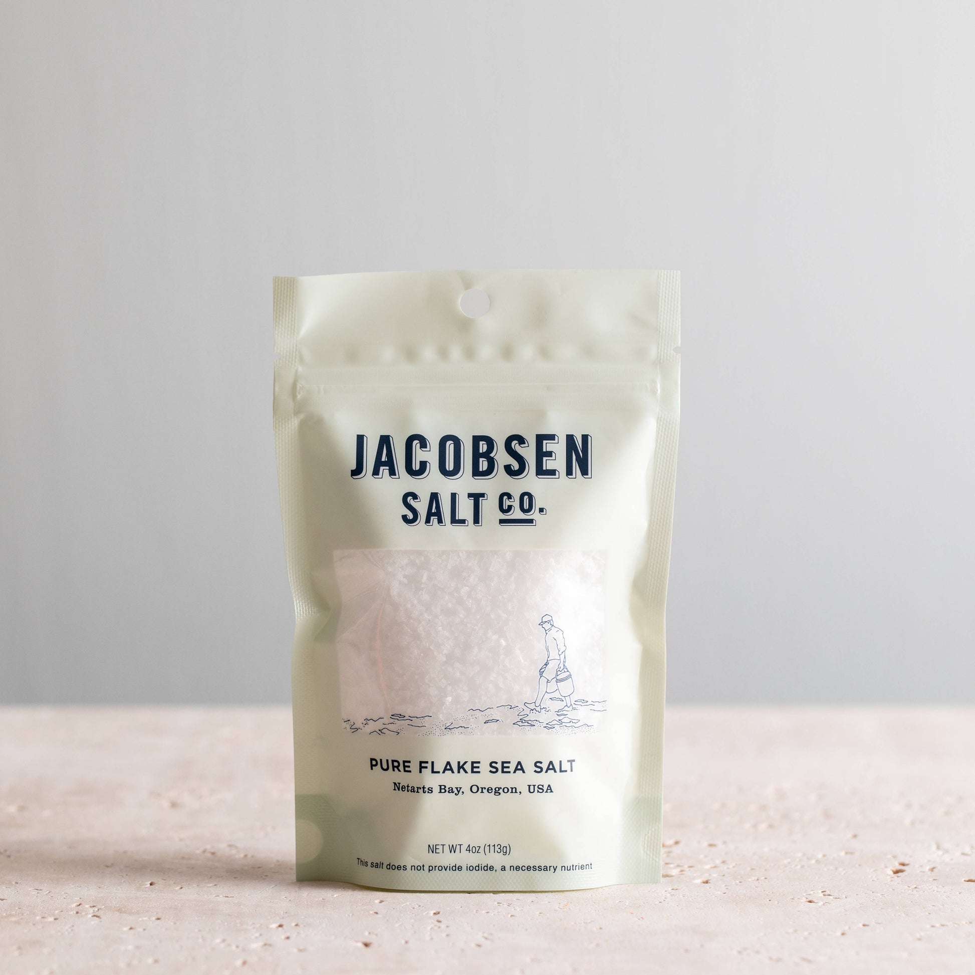 Packaging of Jacobsen Salt Co. pure flake sea salt on a light background