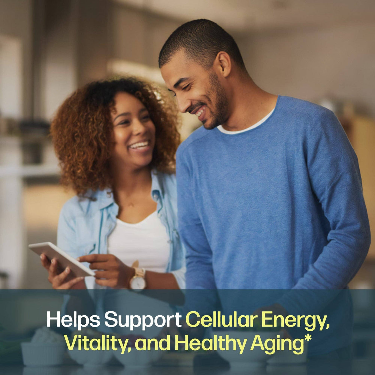 A smiling man and woman standing indoors and looking at a tablet, with overlaid text reading 'Helps Support Cellular Energy, Vitality, and Healthy Aging'.