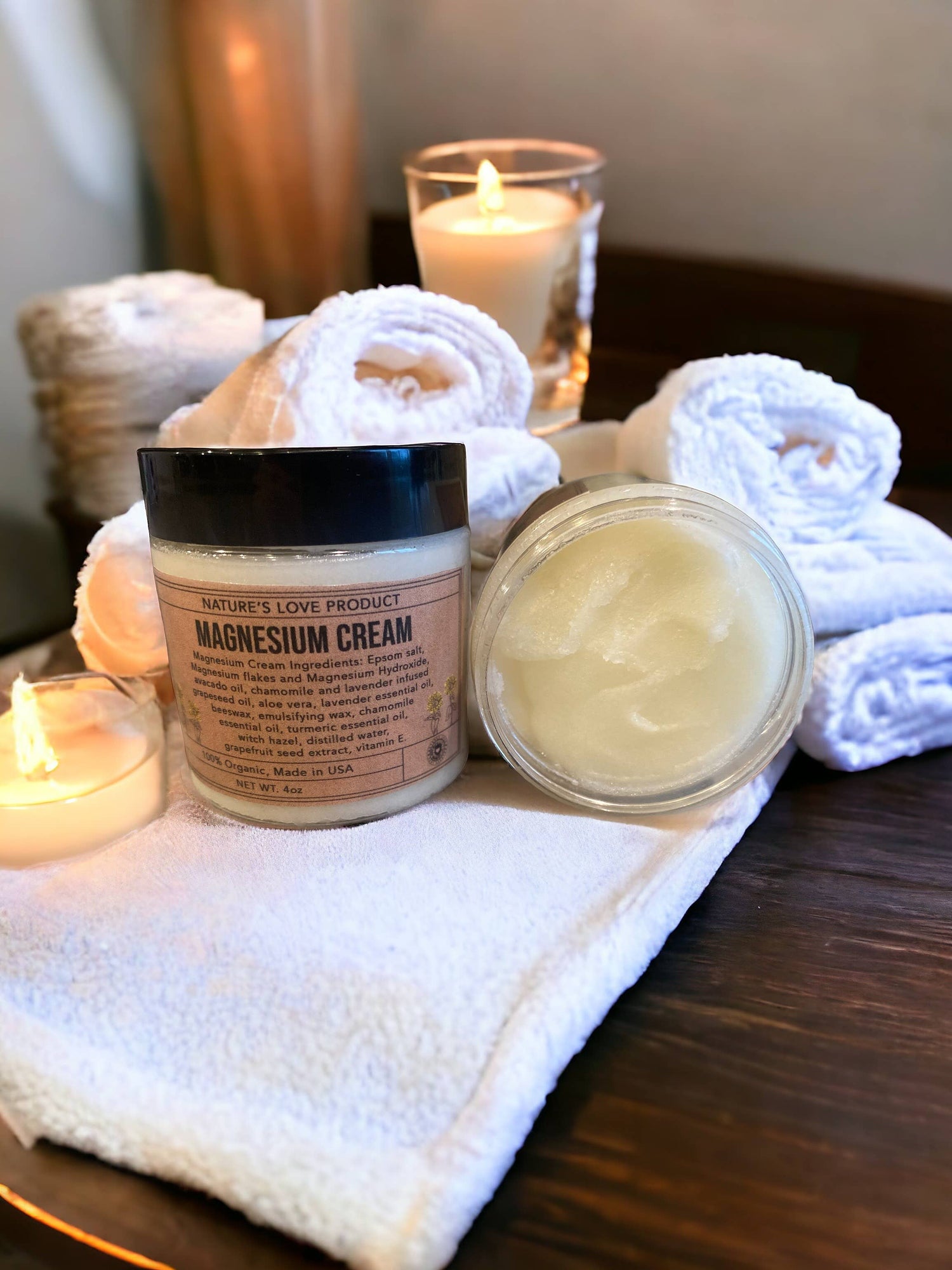 Two jars of magnesium cream on a towel with candles in the background