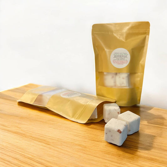 Yellow packaging of Shower Steamers on a wooden surface with a white background