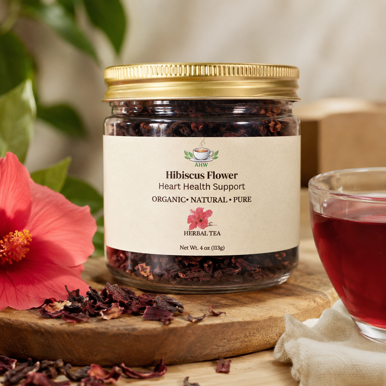 A 4oz glass Jar of hibiscus flower from Ageless herbs wellness herbal tea with a hibiscus flower and glass of herbal tea hibiscus on a wooden board.