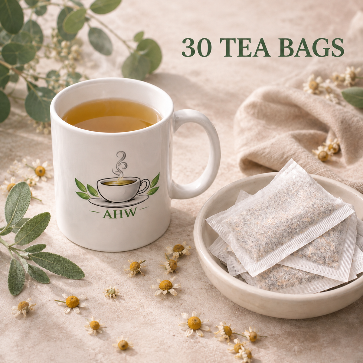 A white ceramic mug filled with tea sits beside a small bowl of tea bags on a beige fabric surface, with scattered chamomile flowers and greenery around it. Text at the top reads 30 TEA BAGS'.