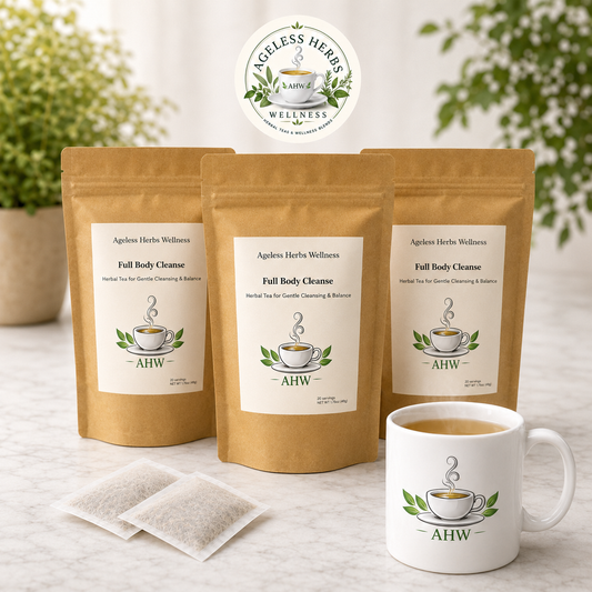 Three stand-up kraft pouches of Ageless Herbs Wellness Full Body Cleanse tea are arranged on a light marble surface, with two single-use tea bags in front and a white ceramic mug with the brand logo and tea inside. The background shows softly blurred potted greenery.