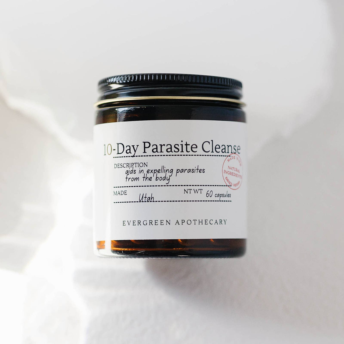 Jar labeled '10-Day Parasite Cleanse' from Evergreen Apothecary on a white background