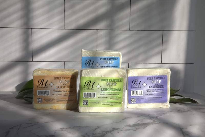 Three bars of soap with visible branding on a marble surface.