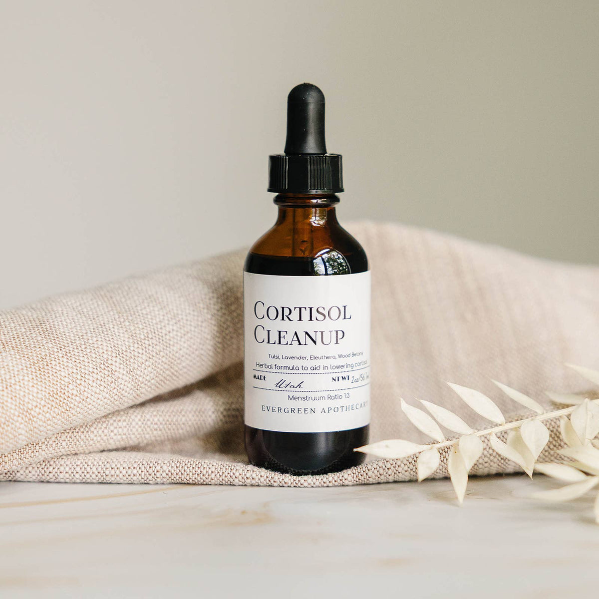Bottle of 'Cortisol Cleanup' on a textured surface with a neutral background