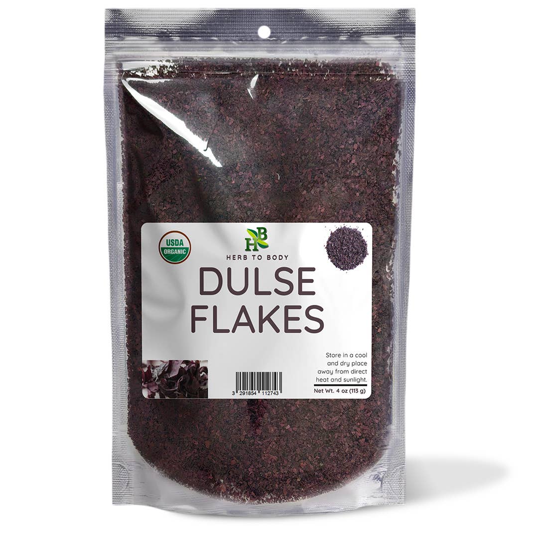 A clear stand-up pouch of herbs to body Dulse Flakes, showing the dark brown dried flakes inside, with a white label on the front.